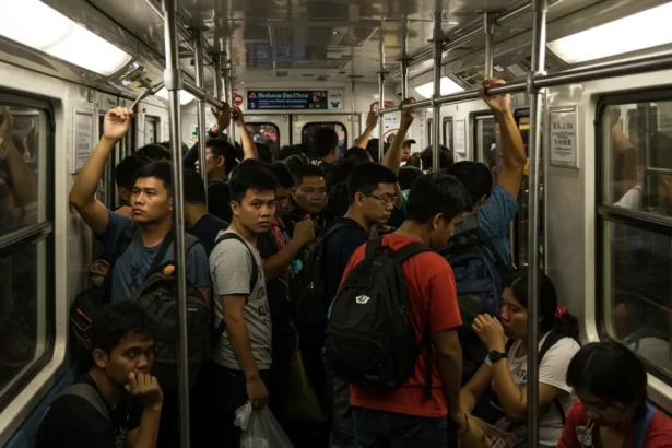 Filipino commuters packed inside MRT Manila during rush hour daily commute Philippines.
