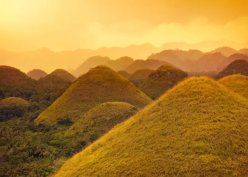 Aerial sunrise view of Bohol’s Chocolate Hills covered in morning mist.