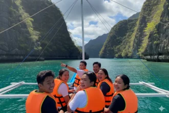 Filipino barkada enjoying a scenic boat ride in Palawan with cliffs and turquoise water in the background