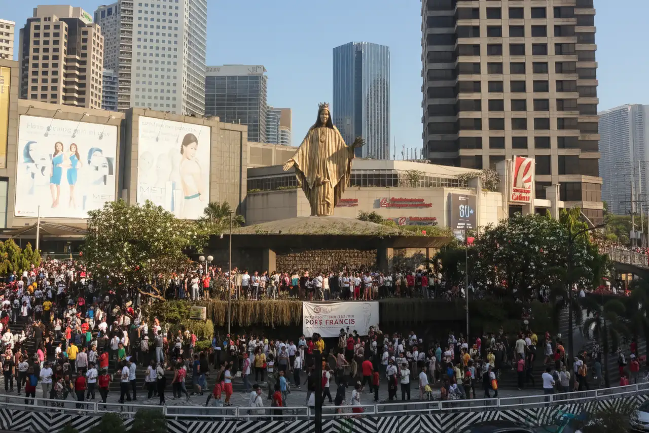 People Power Monument in EDSA at sunset with families and travelers visiting the landmark.