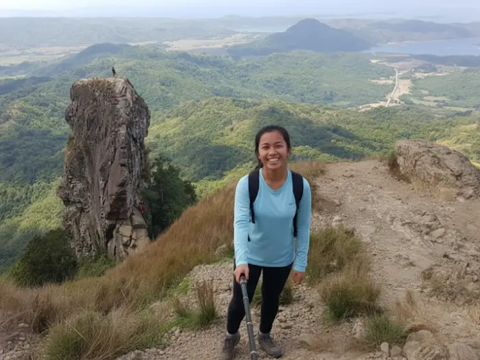 taking a selfie with her phone on a trail overlooking the majestic landscape of Mount Pico de Loro