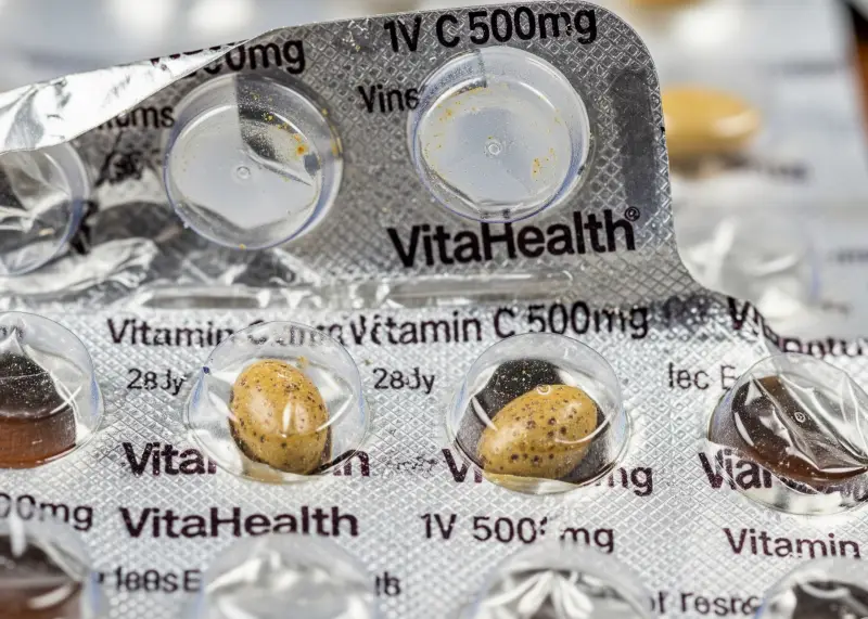 Close-up of suspicious vitamin blister pack with uneven tablets and misprinted foil.