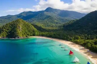 A panoramic shot of Mindanao showcasing a hidden beach, lush mountains, and a cultural festival with dancers in traditional attire.
