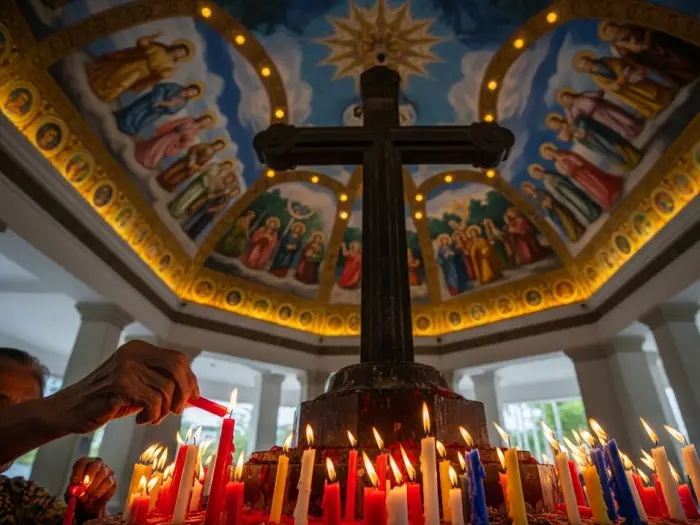 An interior view of the Magellan's Cross Pavilion in Cebu, showing the painted ceiling and a devotee lighting a candle.