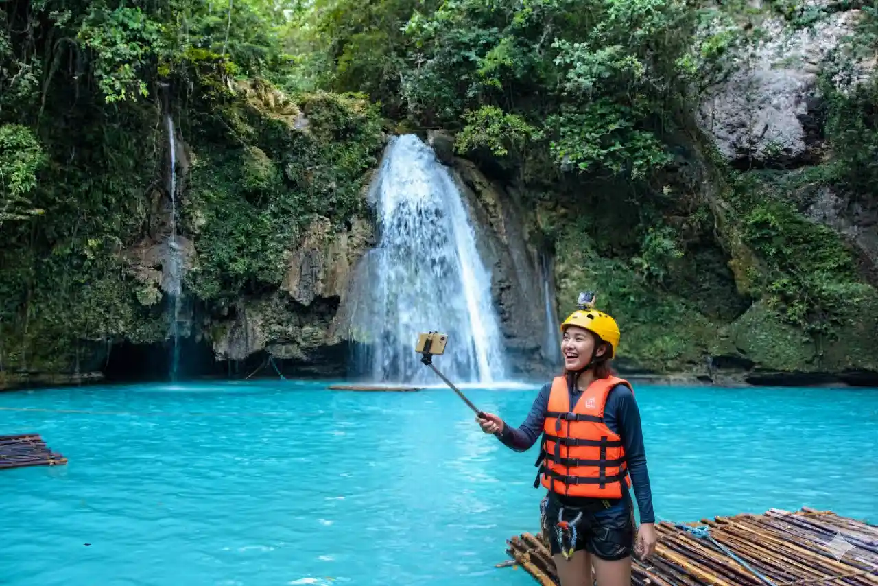 Filipina enjoying a selfie in the turquoise waters at Kawasan Falls in Badian, Cebu.