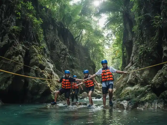 Filipino adventurers trekking through turquoise rivers during Kawasan Falls canyoneering.