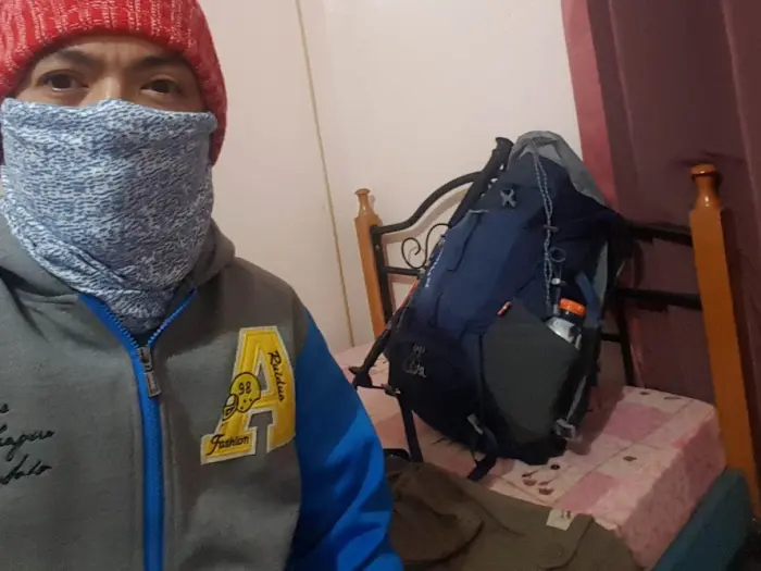 Filipino hiker preparing winter gear and essentials for Mount Pulag’s cold-weather hike.