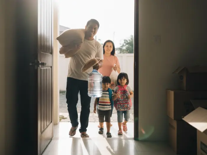 Filipino father bringing rice, water, and bread as the first items into a new home.