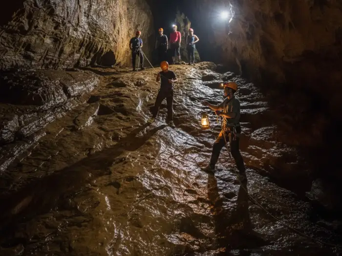 sagada spelunking guide safety ropes Sagada cave guide assists tourists using ropes during the cave connection tour.